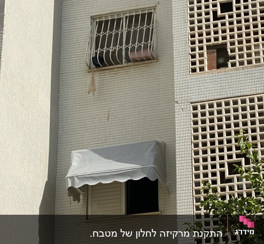 סוכך אפור מותקן מעל חלון בניין